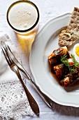 Herring rolls in tomato sauce with egg, crispbread and beer (Sweden)