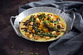 Vegan coconut curry with sweet potatoes, tofu, mushrooms and sausages