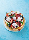 Waffle cake with berries and meringue rosettes