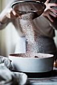 Flour being sieved into a bowl