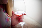 Frau hält Weinglas mit Rosewein