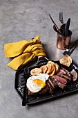 Beef steak with fried egg and potato chips