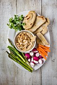 Hummus Dip mit Sesam, dazu Fladenbrot und rohes Gemüse