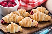 Fresh homemade mini croissants stuffed with raspberries
