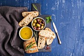 Ciabatta-Brot dazu Oliven, Öl und Kräuter
