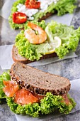 Set of Sandwiches with whole wheat bread, fresh salad, feta cheese, cherry tomatoes, shrimp and salted salmon
