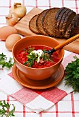 Hearty bowl of homemade red borsch with sour cream and parsley