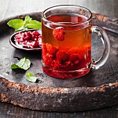 Hot tea with raspberry on dark background