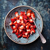 Kleingeschnittene Erdbeeren in blauem Teller