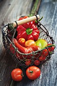 Home-grown sweet peppers and tomatoes on a wooden background