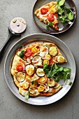 Vegetarian pizza with zucchini, onion, cherry tomatoes, watercress and mozarella