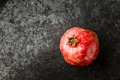 Pomegranate on a grey metal surface