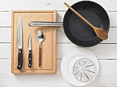 Various kitchen utensils: pan, knife, spoon, measuring cup