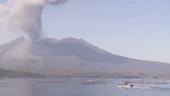 Fishing boat with Sakurajima volcano erupting