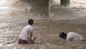 People in flooded river, Philippines