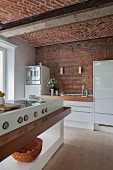 weiße Küche mit Hochglanzfronten, Backsteinwand und Gewölbe