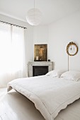 White bedroom with corner fireplace and floating bed