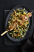 Lemon chicken skewer on a bed of orzo pasta and kale