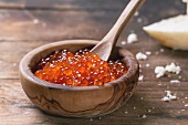 Roter Kaviar in Olivenholzschüssel auf Holztisch