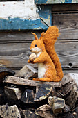 Hand-made, felted, woollen squirrel on firewood