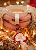 Hände halten Tasse mit weihnachtlichem Heissgetränk