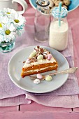 Ein Stück Karottenkuchen mit Orangencreme und Schokoladeneiern zu Ostern