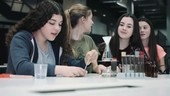 Group of girls practice chemistry at school