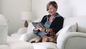 Retired Senior Woman at home on sofa with digital tablet