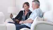 Retired Senior Couple at home with digital tablet