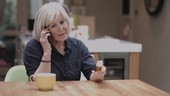 Senior woman on phone holding medicine