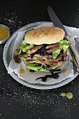 A pulled duck burger with mushrooms