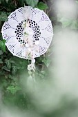 Dreamcatcher made from lace doily hung amongst ivy