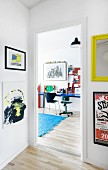 Colourful artworks in hall with view of desk in teenager's bedroom