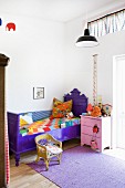 Violett gestrichenes antikes Bett im Kinderzimmer rosa Nachttisch