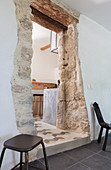 Doorway in old stone wall leading to kitchen