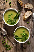 Cream of asparagus and pea soup garnished with peas. fresh asparagus and dill