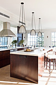 Three hanging lights above the dark wood kitchen island