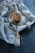 Ostereier mit Tiermotiv-Aufkleber auf Silberlöffel