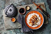 Eel on Rice with sauce and sesame and green tea on stone slate background
