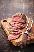Roast beef on cutting board and meat fork