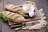 Sandwich with smoked salmon and coffee on vintage slate chalk board background