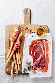 Bread sticks with ham on wooden cutting Board