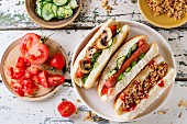 Assortment of homemade hot dogs with sausage, fried onion, tomatoes and cucumber