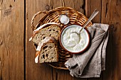 Clabber sour milk and brown rye bread on wicker tray on wooden background