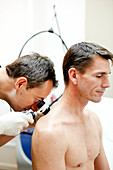 Dermatologist examining patient