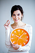 Woman holding clock and pill