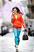 Woman walking on street with umbrella