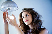 Woman using energy saving bulb