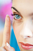 Woman applying contact lens