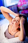 Woman waking up and stretching in bed